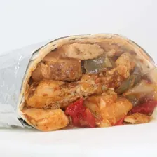 A burrito cut in half, filled with chicken, bell pepper and tomato