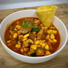 Beef caldo with corn and vegetables in a deep bowl