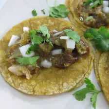 Guisado tacos on corn tortillas with onion and cilantro
